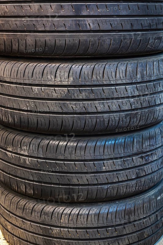 Close-up of four stacked black rubber automobile tires with deep grooves in home garage, Quebec, Canada
