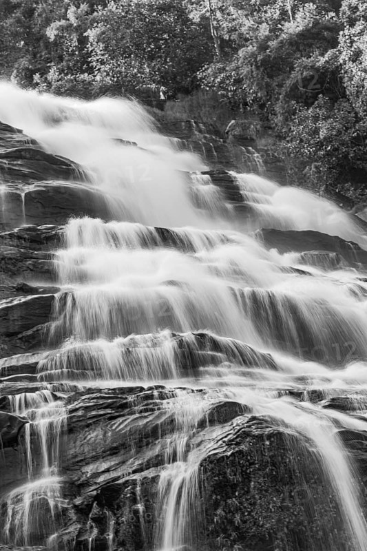 Mae Ya waterfall with cascading flowing water framed by lush tropical vegetation, black and white photo, near Doi Inthanon National Park, Chiang Mai Province, Thailand