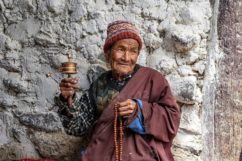 Elderly man with Buddhist stone mill and prayer necklace, Mala, in traditional dress, Lo Manthang, Mustang, Upper Mustang, former kingdom, Himalayas, Nepal