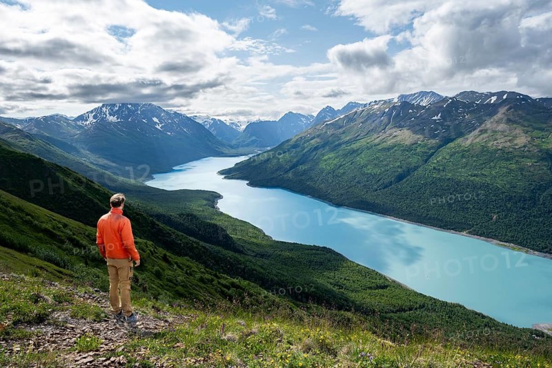 Mountaineer enjoys views of blue lake and mountains on Twin Peaks Trail, Eklutna Lake, Chugach Mountains, Chugach State Park, Alaska, USA