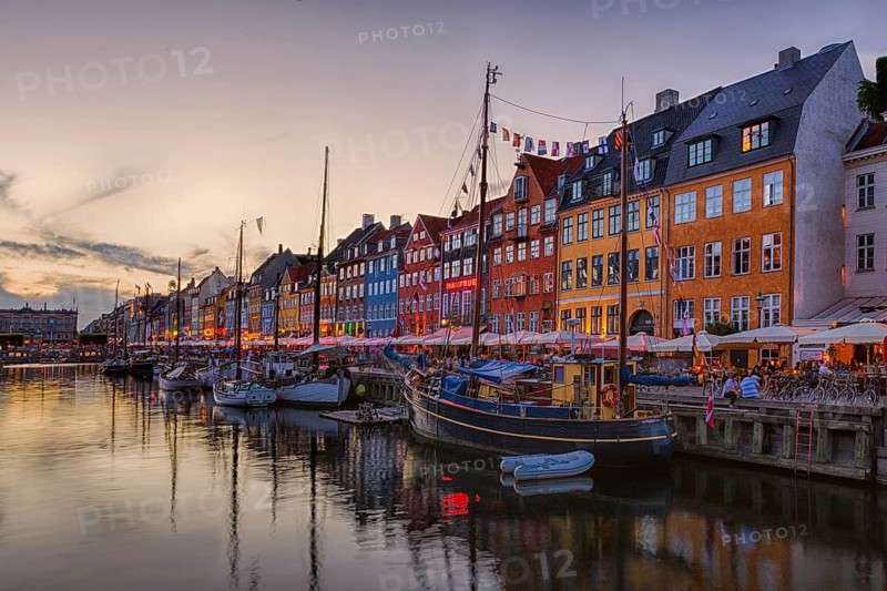 Abend in einem historischen Hafen mit traditionellen Häusern und Booten im Wasser, Kopenhagen, Dänemark, Nyhavn