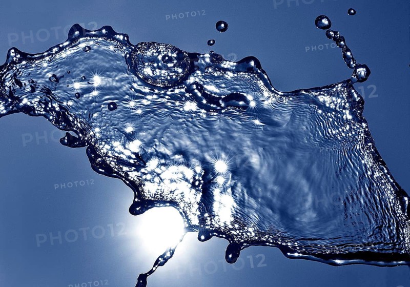 Water frozen by short exposure moving in backlight in front of the sun, duplex toning in blue
