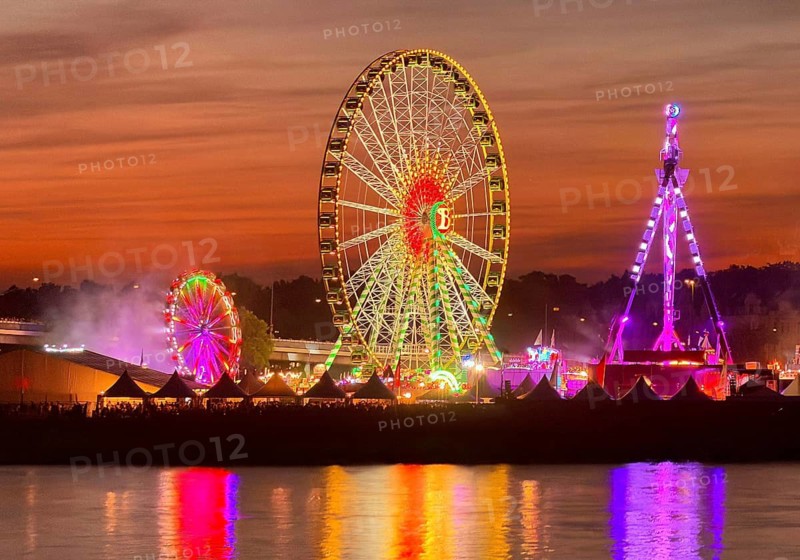 Rheinkirmes, largest funfair on the Rhine in a colorful sunset with a view over the river, Düsseldorf, North Rhine-Westphalia, Germany