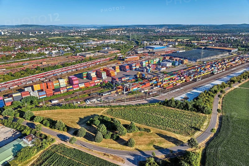 Aerial view of a large container terminal with freight trains, shipping containers, cranes, and rail logistics infrastructure surrounded by farmland. Kornwestheim, Baden-Württemberg, Germany