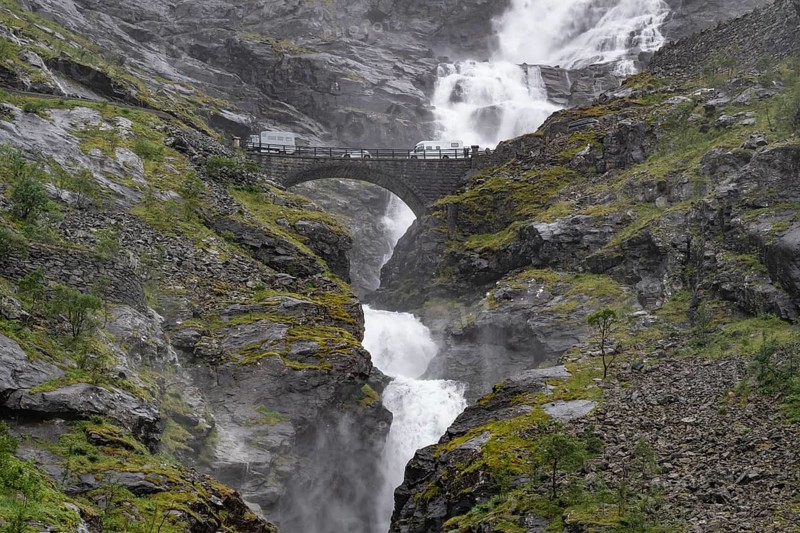 Motorhome on a bridge in front of heavily swollen Stigfossen waterfall, Trollstigen, near Åndalsnes or Andalsnes, Rauma municipality in the province of Møre og Romsdal, Norway