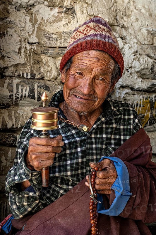 Elderly man with Buddhist stone mill and prayer necklace, Mala, in traditional dress, Lo Manthang, Mustang, Upper Mustang, former kingdom, Himalayas, Nepal
