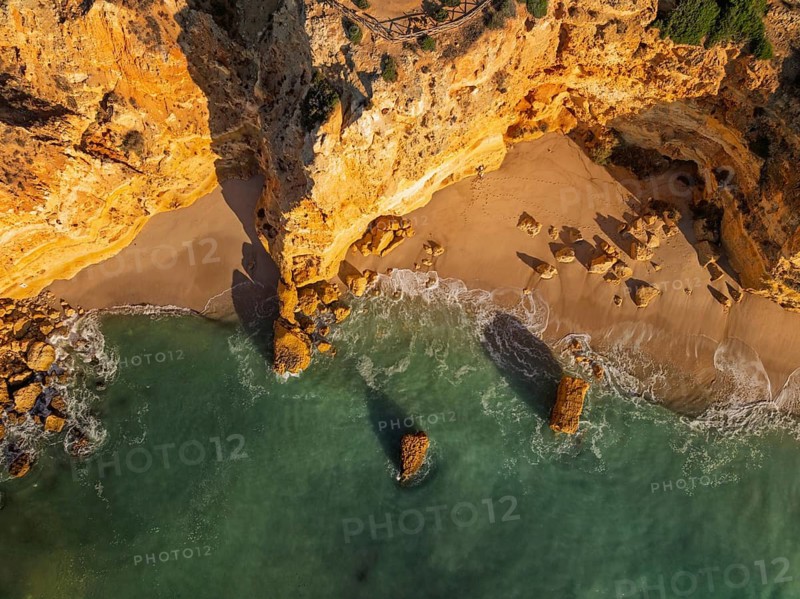 Drone top down view of Praia da Marinha beach in Algarve, Portugal, with ocean cliffs, sea stacks and surf patterns