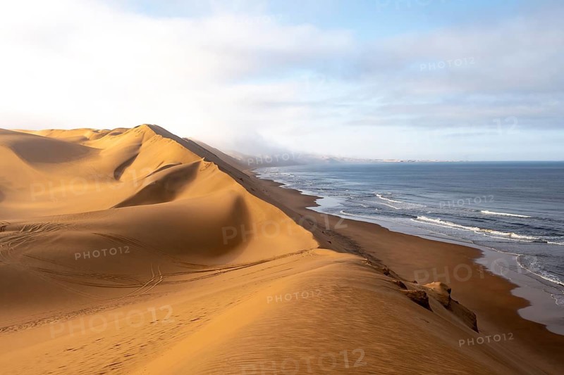 Sand dunes and sea with coastal fog in the morning, Atlantic coast and sandy desert with sea of dunes, Sandwich Harbour, Namib Naukluft Park, Namib Desert, Namibia
