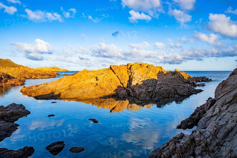 Landscape of the coastline with blue water at Marinedda Coast at sunset, Sardinia, Italy