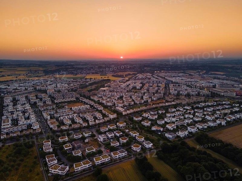 The sun rises behind the houses in Frankfurt's Riedberg district, Germany