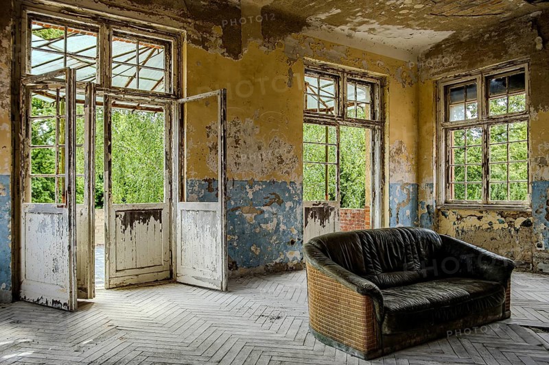 Vacant sofa in the so-called Saal des Sofas, former lung sanatorium and lost place Heilstätte Grabowsee, Oranienburg, Brandenburg, Germany