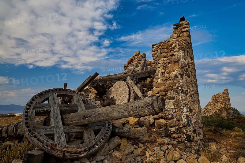 Abandoned ruin of an old windmill under blue sky, main town on Kimolos, Kimolos, Chorio, Kimolos island, neighboring island of Milos, Cyclades, Greek Islands, Greece