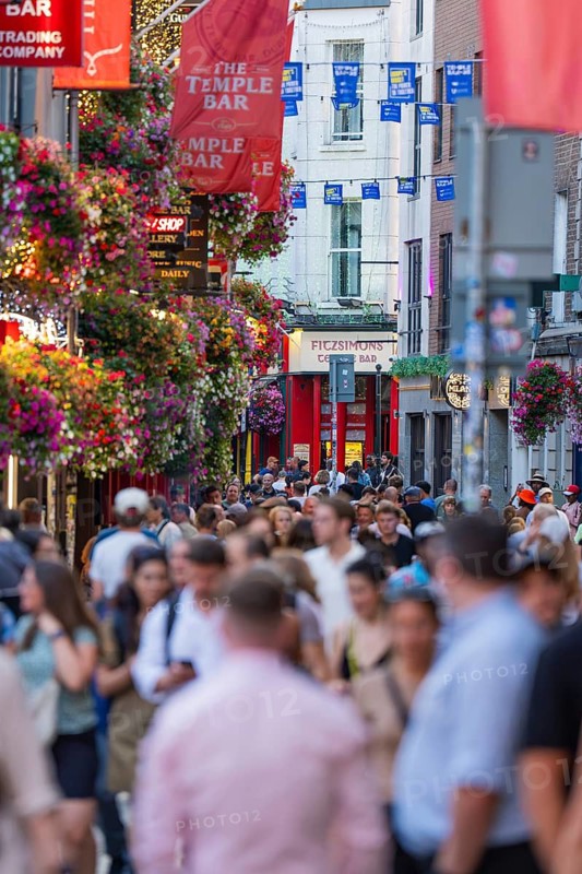 Busy street with crowds, colorful hanging baskets and banners, Dublin, Ireland