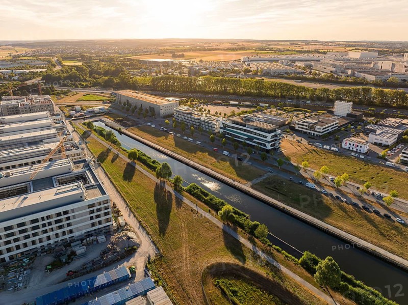 Urban landscape with office buildings and canal in warm sunset light, airfield, Böblingen, Germany