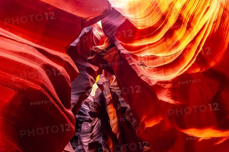 Sandstone rock walls creating a narrow slot canyon with swirling shapes and vibrant colors, displaying the geological beauty of antelope canyon in arizona