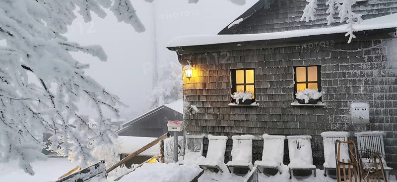 Snowy hut, Kösseinehaus with warm lights in a winter landscape, hiking in winter, Fichtelgebirge nature park Park