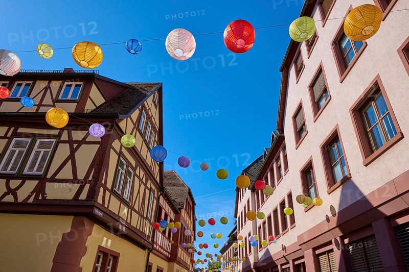Colourful lanterns stretch across a street with half-timbered houses on a clear day, Lohr am Main, Schneewittchenstadt, Main-Spessart district, Mainfranken, Lower Franconia, Bavaria, Germany