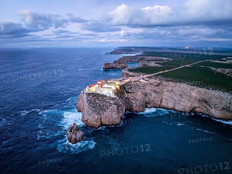 Drone view of the Lighthouse of Cabo de Sao Vicente in Sagres, Algarve, Portugal, at evening with shoreline surf and Atlantic ocean
