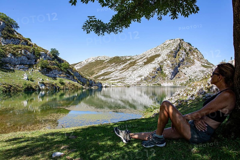 Middle aged woman contemplates the Ercina lake, Covadonga lakes ensemble, Picos de Europa National Park, principality of Asturias, Spain