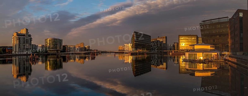 Moderne Gebäude spiegeln sich im ruhigen Wasser bei Sonnenuntergang, Kopenhagen, Dänemark