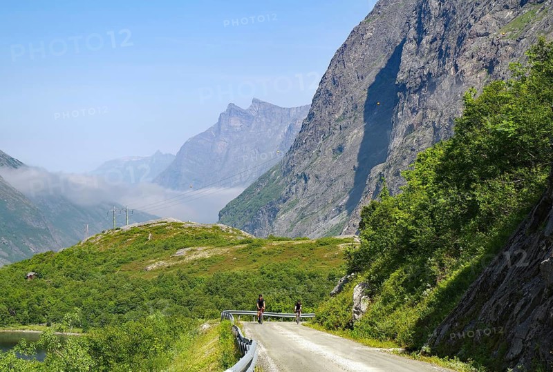 Cyclists on a mountainous, spectacular road surrounded by green nature, Eikesdalen, Eikesdalvatnet, Aursjövegen, More og Romsdal, Norway