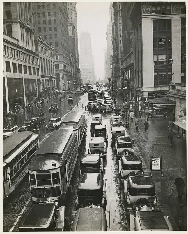 New York, 42nd Street, rain, traffic, streetcar, shops, department stores, Manhattan, USA, heavy traffic on a rainy city street between tall buildings, around 1935