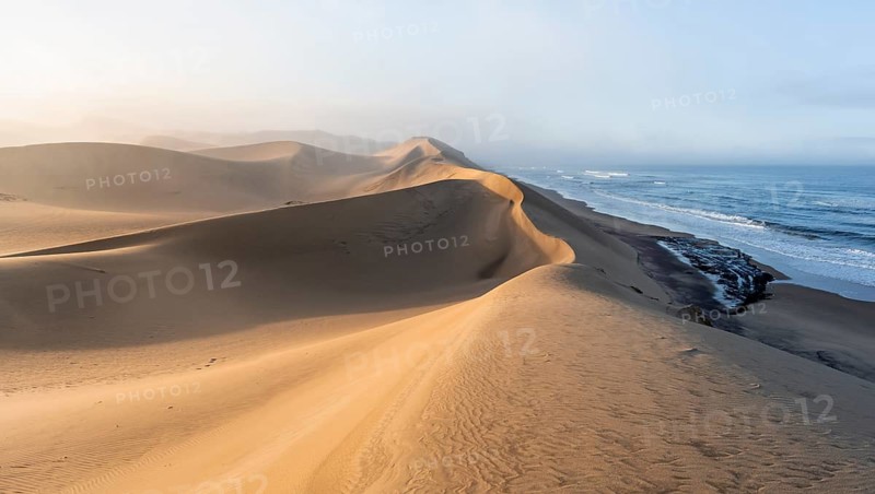 Sand dunes in morning light, view of Atlantic coast and sea, Sandwich Harbour, impressive desert landscape, Namib Naukluft Park, Namibia