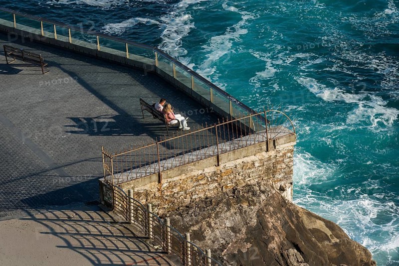 Couple looking at the sea on the seafront in San Sebastian, Spain