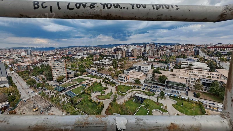 View of Pristina from above, with graffiti in the foreground and cloudy sky, Pristina, Kosovo