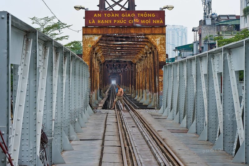 Vietnamese man walks across the tracks of the Long Bien railway bridge across the Red River, Hanoi, Ha Noi province, Vietnam