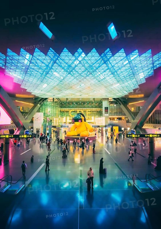 Doha, Qatar - 23rd, january, 2026: Hamad International Airport terminal with travelers passengers. Iconic Lamp Bear artwork modern architecture busy passenger flow global travel hub Qatar