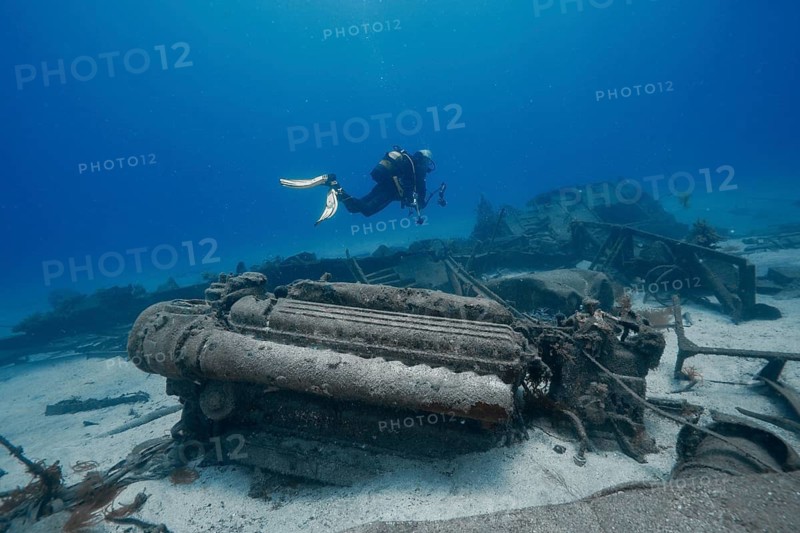 A diver swims across the engine of a large wreck on the seabed, the surrounding area is sandy and blue, meteor wreck dive site, Russian hydrofoil, Arguineguin, Gran Canaria, Spain, Europe, Atlantic