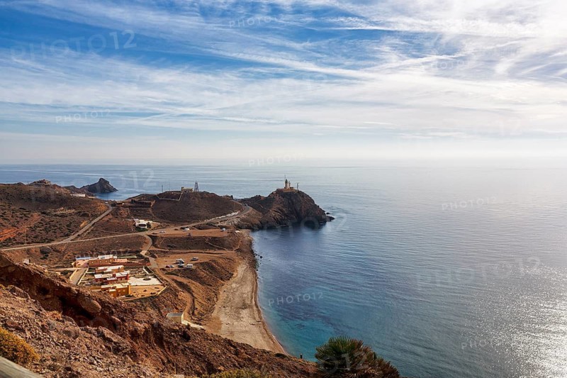 Distinctive Cape Cabo de Gata, Faro de Cabo de Gata lighthouse on the cliffs, holiday homes, Cala del Corralete sandy beach, view from above of volcanic desert landscape, Cabo de Gata-Nijar nature park Park, Almeria, Andalusia, Spain