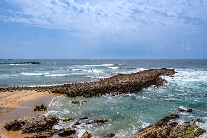 Rocky coastline with foaming waves and sweeping views of the sea, Vila Nova de Milfontes, Beja, Portugal