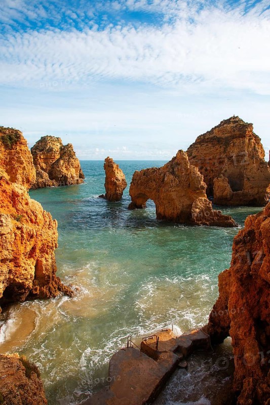 Rock arches and cliffs rise from turquoise water in a picturesque coastal area, rocky sandstone coast, rock formations in the sea, Algarve, Lagos, Portugal