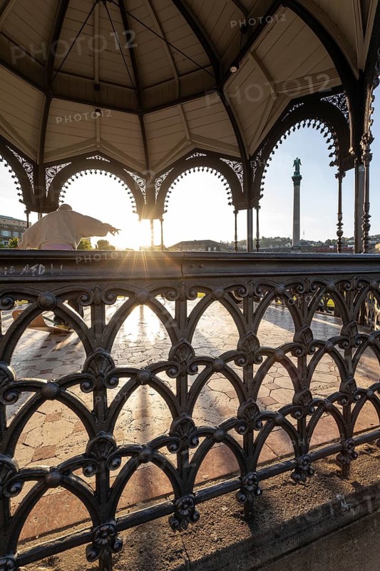 24.4.2026: The ornate cast iron music pavilion on Schlossplatz at sunrise. Sun star effect through the structure and long shadows on the pavement. Stuttgart, Baden Wuerttemberg, Germany