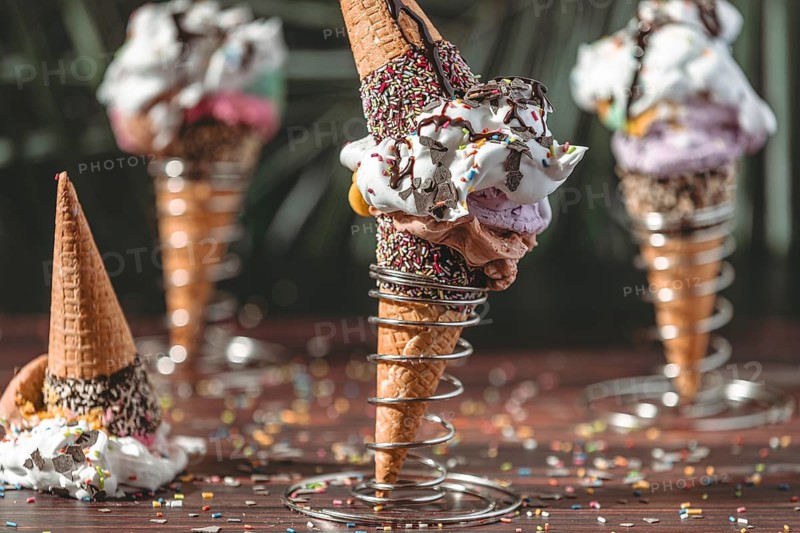 Ice cream cones with ice cream, chocolate sauce and colorful sprinkles