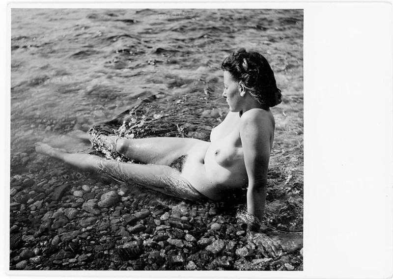 Bathing, nude photography, grace, beauty, woman sitting in shallow water on stones, enjoying the quiet surroundings and the water, Dr. Eduard Petertil, Vienna, 1902-1941, around 1930