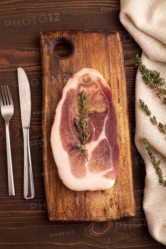 Dry-aged steak, Pork ham with thyme on brown wooden background and linen textile. top view, flat lay, close up