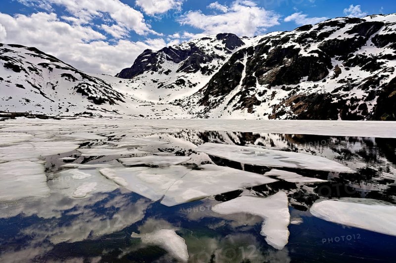Ice floes float in the half-frozen Upper Murgsee, Murgtal, Canton of St. Gallen, Switzerland