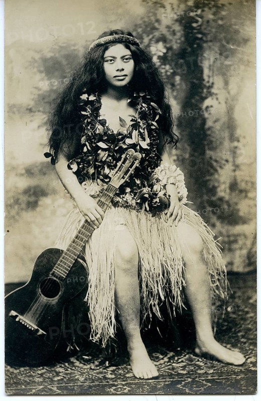 Hawaii, South Pacific, beauty, ethnic, bastrock, woman in traditional Hawaiian clothing with a wreath of flowers sitting barefoot with a guitar. Exotic appearance, around 1910
