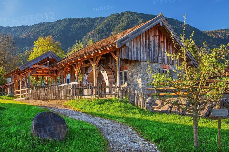 Historic Schleifmühle, water mill, in the village in spring, Ohlstadt, Loisach Valley, The Blue Land, Upper Bavaria, Bavaria, Germany