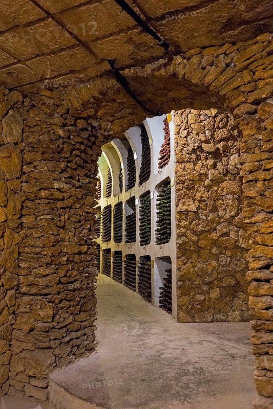 Cosy wine cellar with stone walls and bottle racks in a cave-like room, wine cellar, Milestii Mici Winery, Mile?tii Mici, Republic of Moldova, Moldova