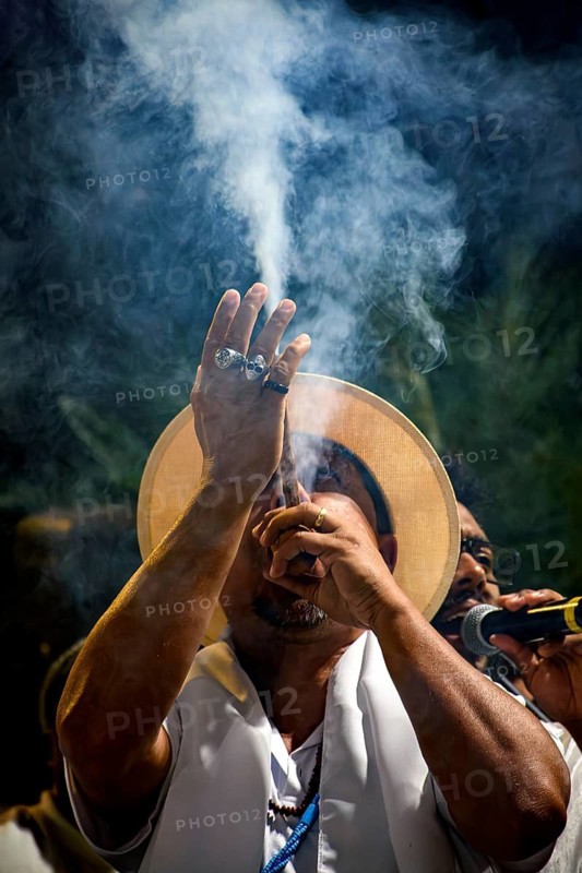Belo Horizonte, Minas Gerais, Brazil - May 17th 2025 - Man blowing smoke from his pipe during a religious celebration of Umbanda, Belo Horizonte, Minas Gerais, Brazil
