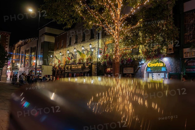 Charming, illuminated street with decorative lights and relaxed people, nightlife, Dublin, Ireland