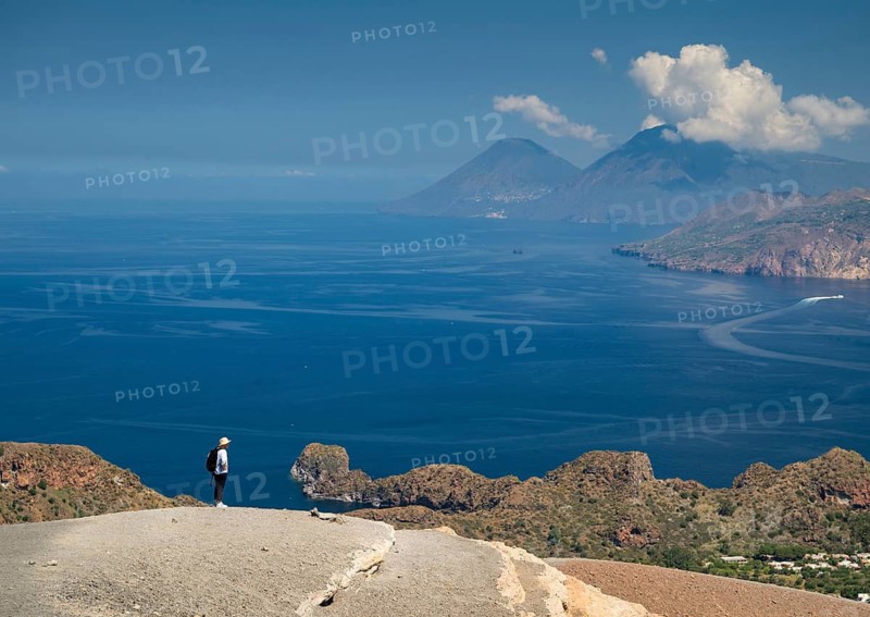 Visitor standing at the crater rim, Vulcano, in the background Lipari and Salina, Aeolian or Lipari Islands, Sicily, Southern Italy, Italy