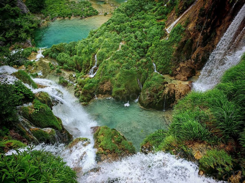 View from above of bubbling waterfalls in the middle of a green gorge, Plitvice Lakes National Park, Croatia