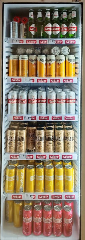 Beverage refrigerator filled with various types of beer in cans and bottles in a shop, Montenegro
