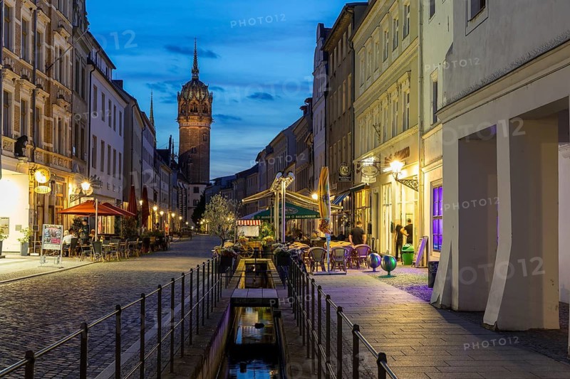 Schlossstraße in the evening with castle church tower and Röhrwasser, Luther city Wittenberg, Saxony-Anhalt, Germany