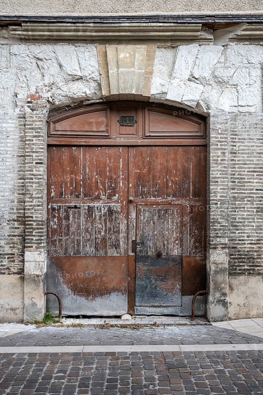 Old, weathered wooden door with weathered stone arch in the old town of Troyes, Aube department, Grand Est region, France